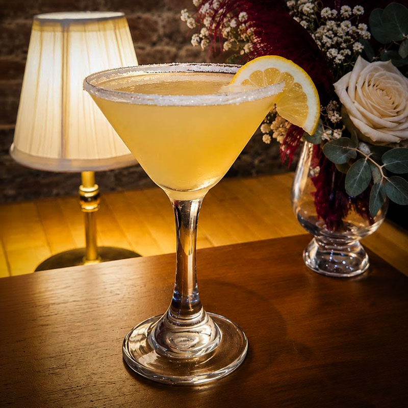 A Golden Hemline Cocktail with a lemon wedge