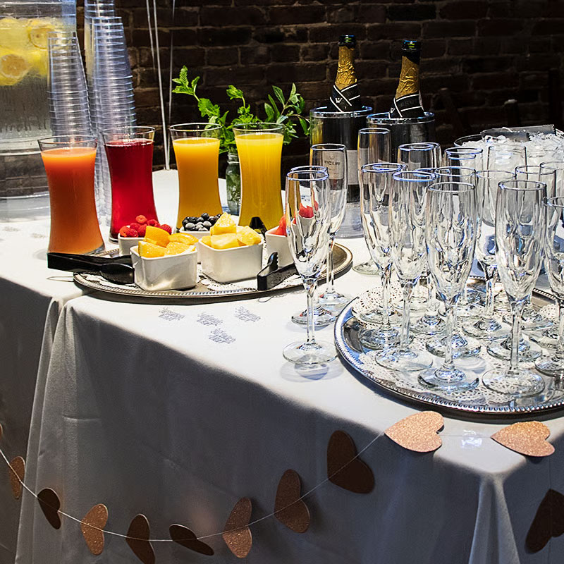 A table set up with drinks and fresh cut fruit