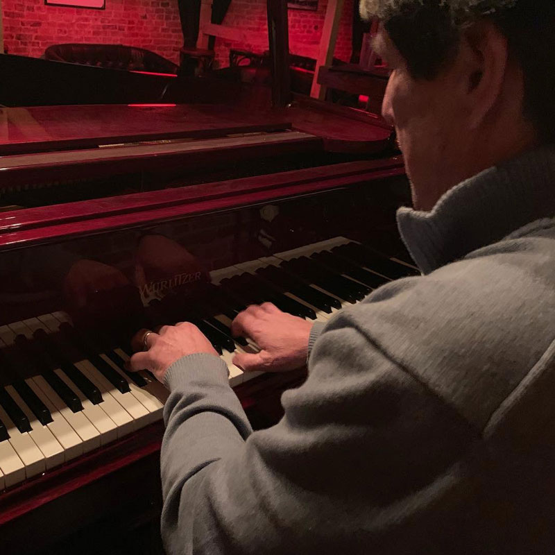 Man playing a baby grand piano